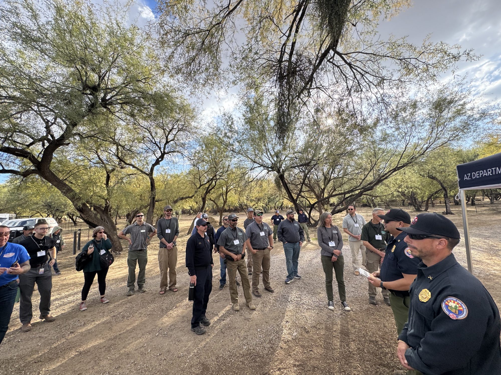 Arizona Department of Forestry prevention staff standing near trees in the Sonoran Desert to discuss their outreach strategies with colleagues at the 2024 AZ WUI Summit.